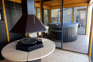 The interior of the BBQ section of the Garden Cube with painted black walls and pine (wood stain) ceiling - the BBQ in the centre of the room