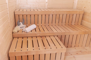 The interior of the Sauna section of the Garden Cube with wooden walls and matching staggered seating