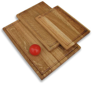 A white background image showing the selection of 3 different sized chopping boards with a tomato on top the largest ones.