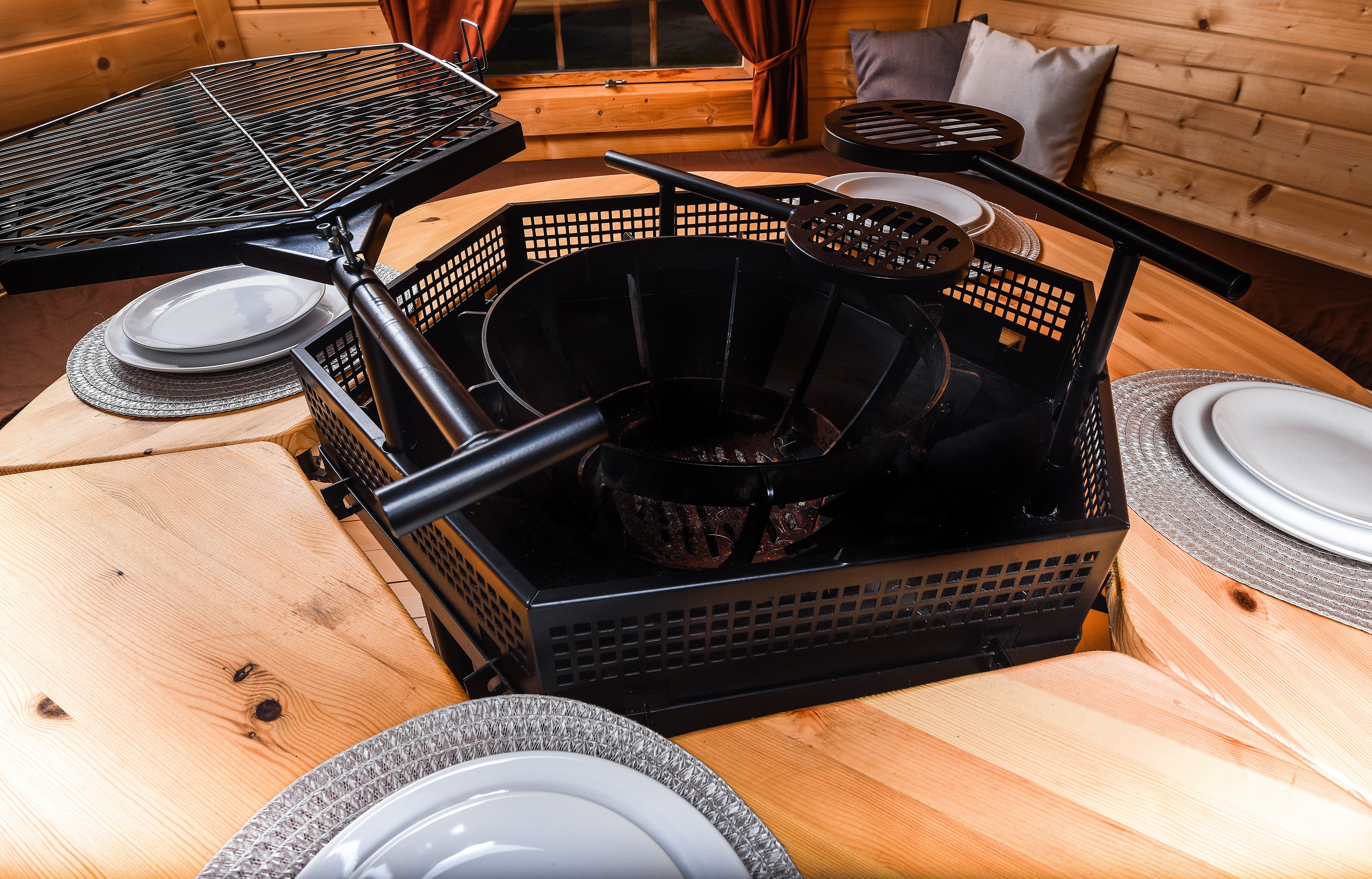 A close up shot of the firewood ring surrounded by the tables and tableware.