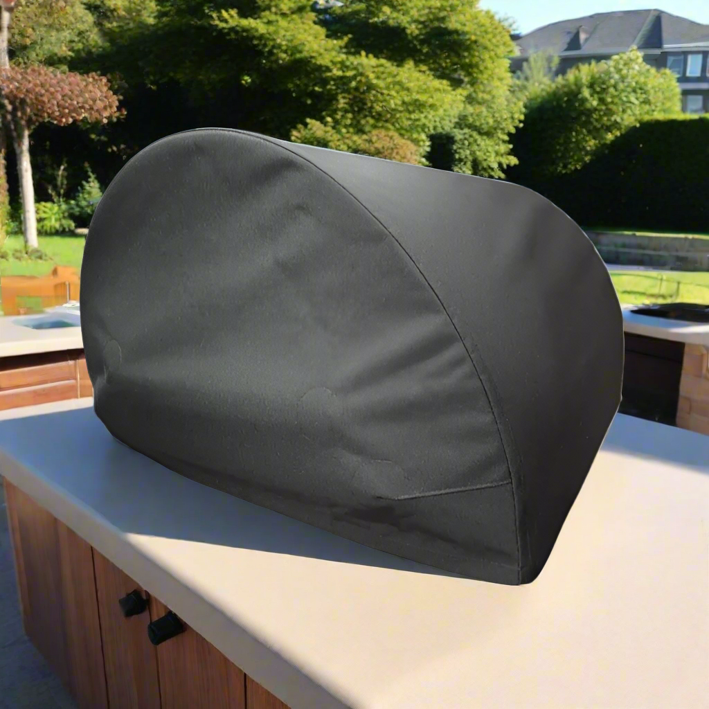 Black pizza oven cover in a modern garden on a sunny day sat on a kitchen counter