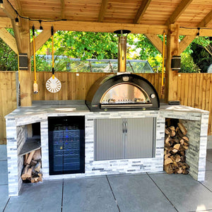 A black sided Clementi pizza oven outdoor in an outdoor kitchen undercover.