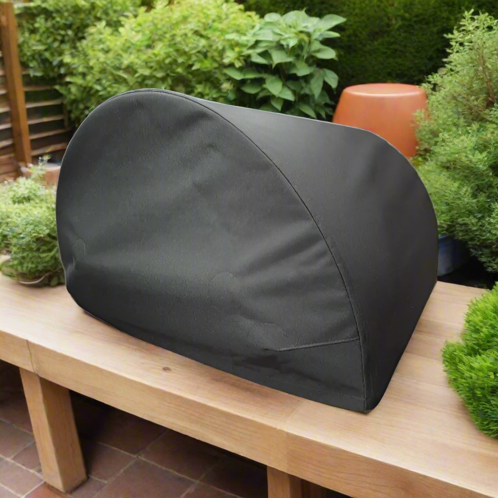 Black pizza oven cover in a modern garden on a sunny day sat on a kitchen counter