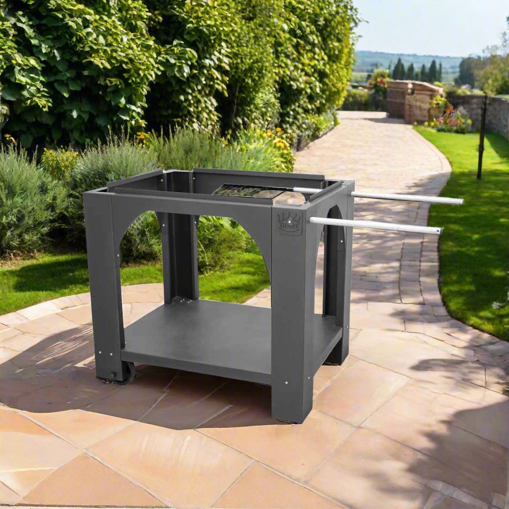 A four legged pizza oven stand with two white handles for ease of moving set in a modern garden on a sunny day