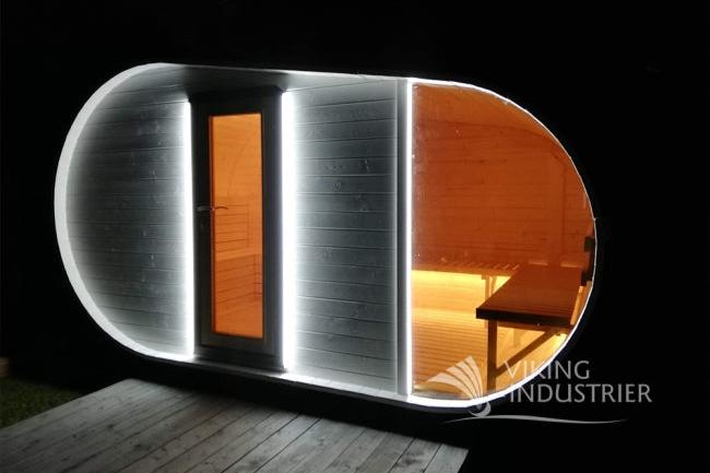 The Delight sauna pictured at night with bright lights framing the door and window