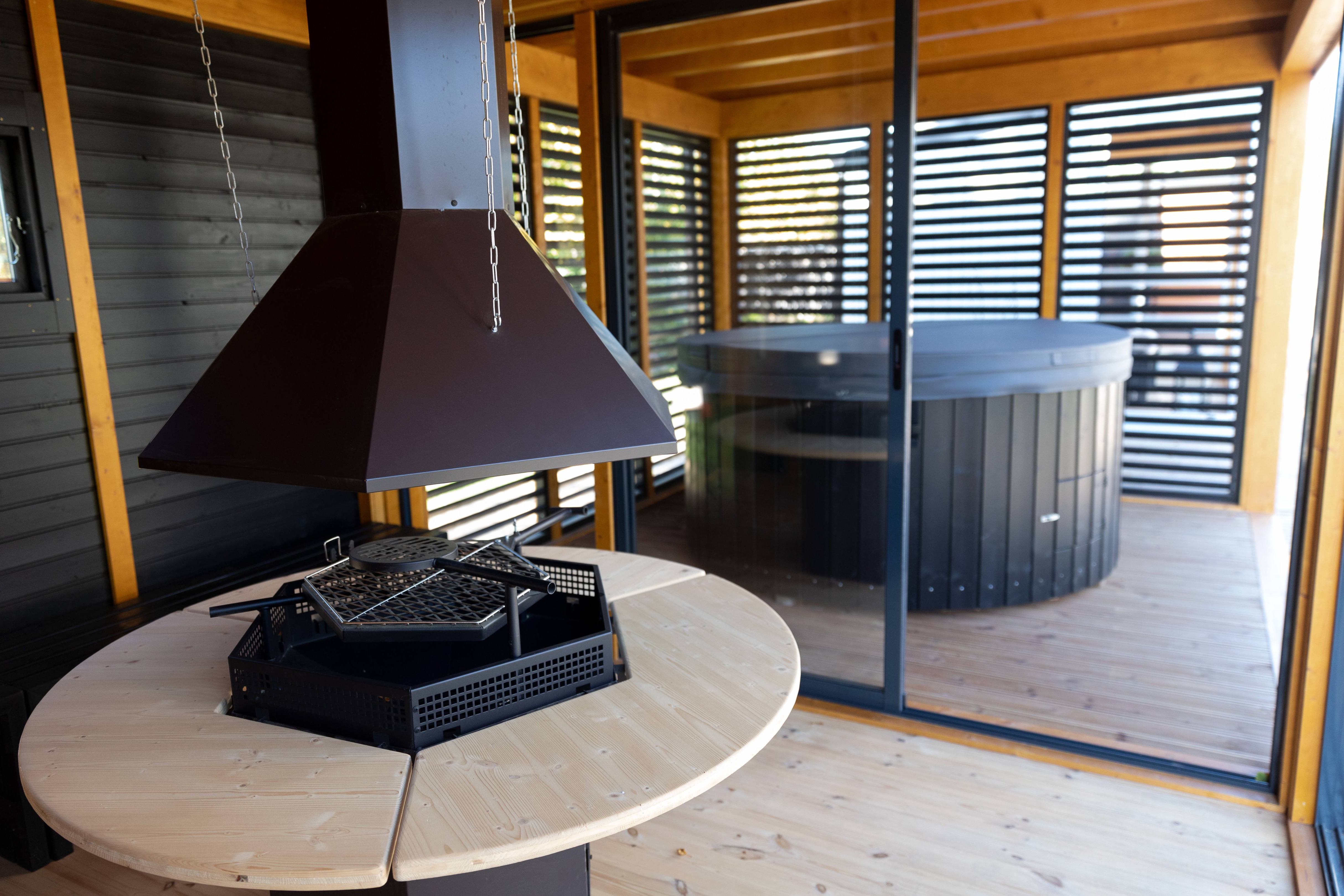 The interior of the BBQ section of the Garden Cube with painted black walls and pine (wood stain) ceiling - the BBQ in the centre of the room