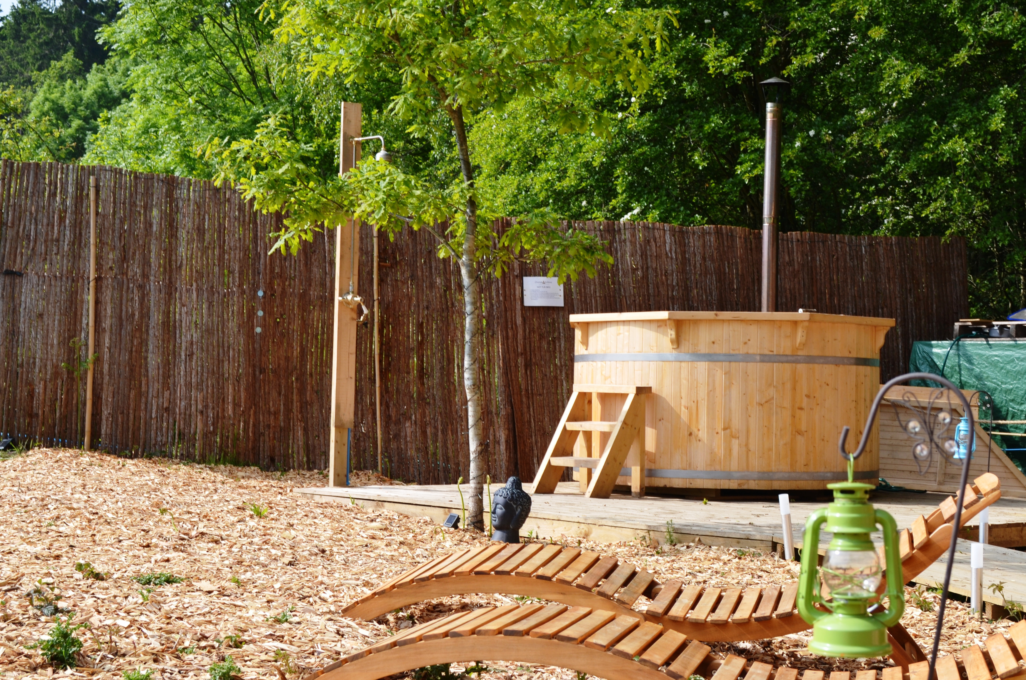 A light oak finish on the 8 person hot tub with some deck chairs sat in front.