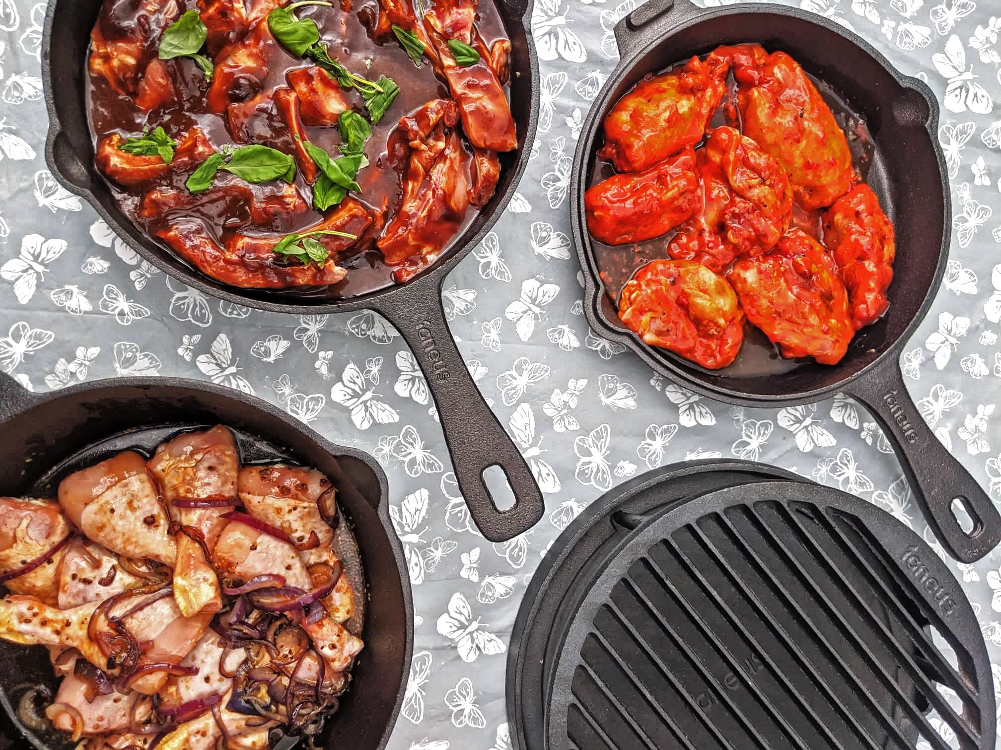 Another top down photograph of the igneus 3 part cast iron set and the tuscan grill - the 3 part set shows the cooking options with an assortment of seasoned chicken dishes, vegetables and marinades