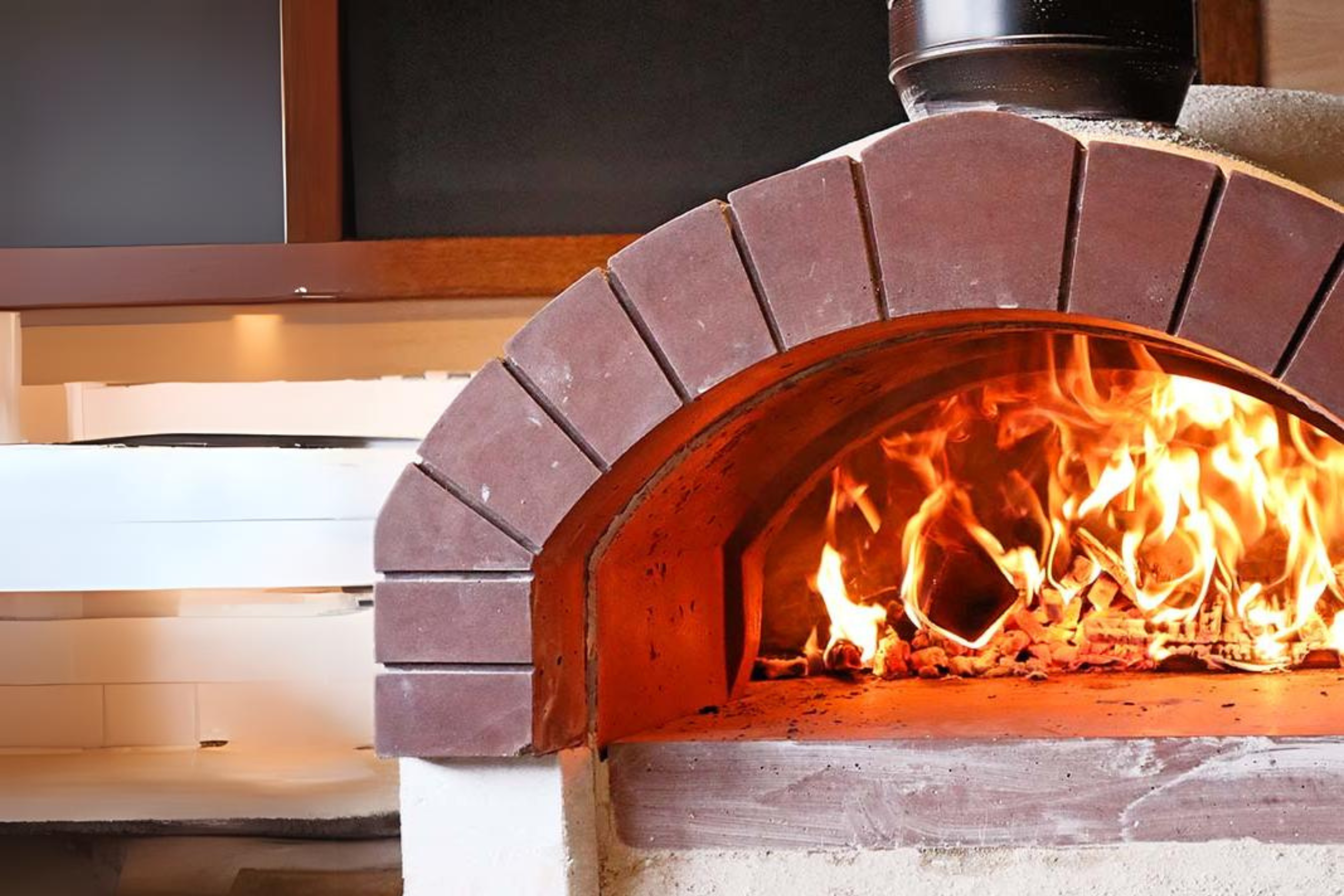 The Ceramiko Pro 1200 wood fired pizza oven in a modern kitchen with flames roaring inside