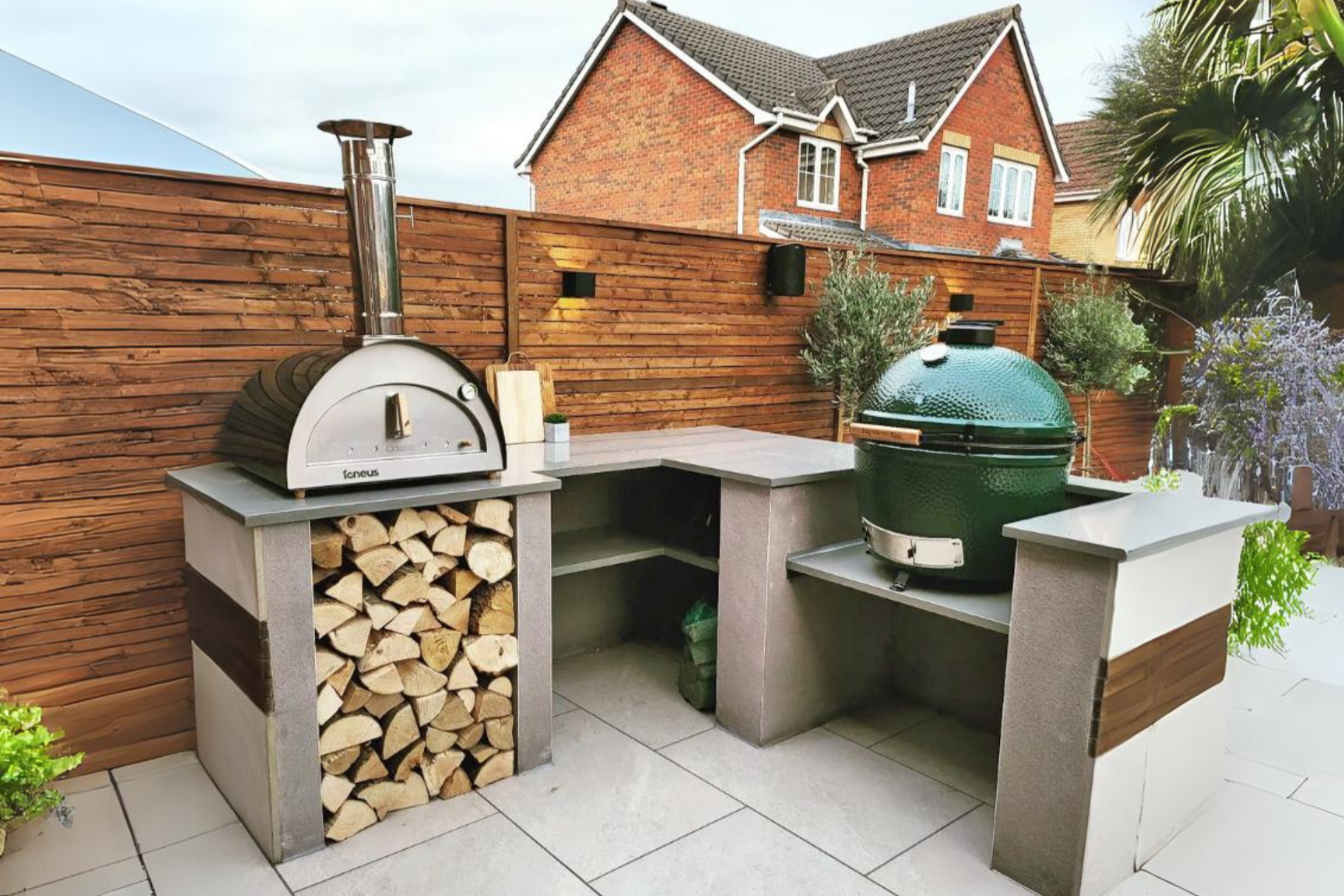 Pizza ovens for outside cooking station including the Classico pizza oven exterior in black in a modern, floral garden