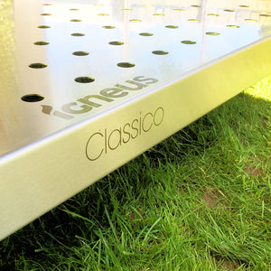 Another close up shot of the Igneus Classico logo on a silver metal pizza oven outdoor stand on some grass