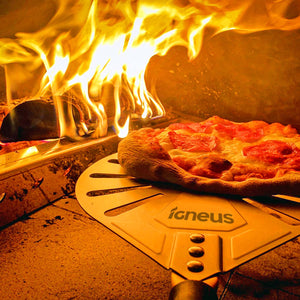 A close up image of the Igneus pizza oven spinner inside of a lit oven moving a cooked pizza.