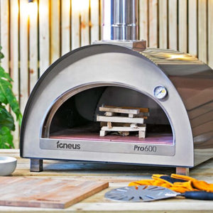 An image of the Pro 600 pizza oven outdoor with kindling ready to be lit on top of the professional fire bricks.