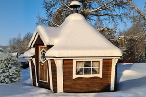 The BBQ Hut with nut wood (wood stain) walls within a garden covered in snow