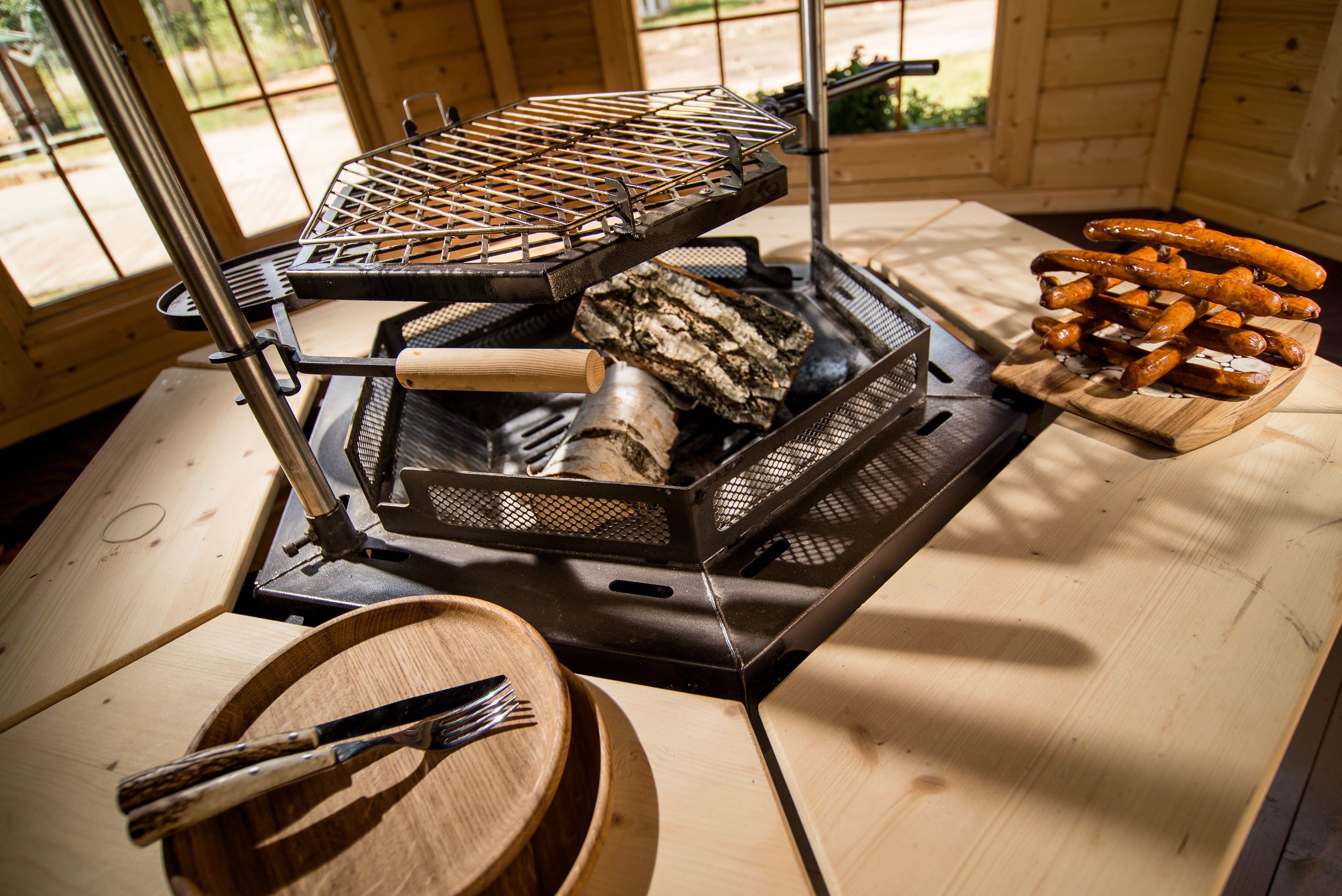 A close up shot of the Luxury grill for BBQ Hut's with some food and table ware on the 8 corner tables.