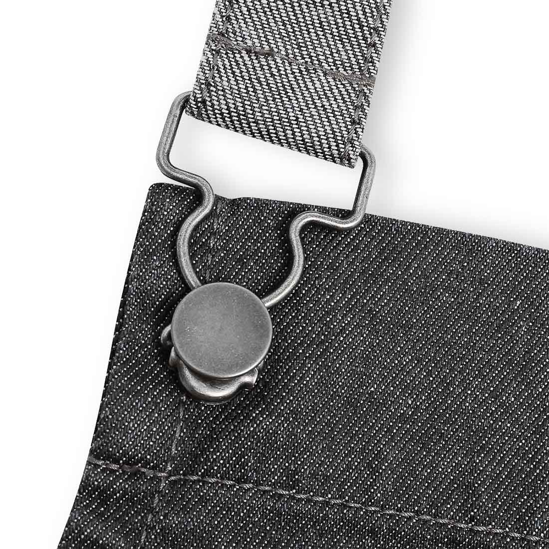 A close up shot of the was look denim apron showing the metal clip for the neck part.